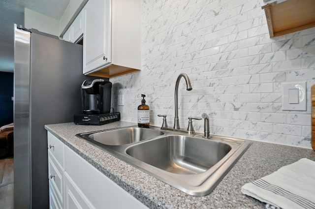 248 Grandview Ave, Delaware, OH 43015 - kitchen featuring decorative backsplash, freestanding refrigerator, and white cabinetry