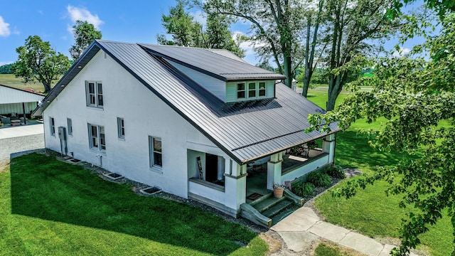 6997 State Route 734, Jamestown, OH 45335 - view of home's exterior featuring stucco siding, a metal roof, a standing seam roof, and a yard