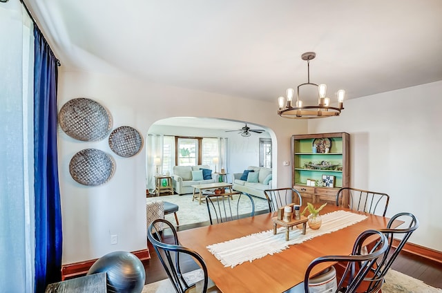 6997 State Route 734, Jamestown, OH 45335 - dining space with arched walkways, wood finished floors, a chandelier, and a ceiling fan