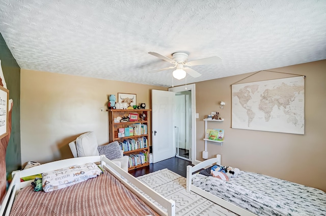 6997 State Route 734, Jamestown, OH 45335 - bedroom with a textured ceiling, wood finished floors, baseboard heating, and a ceiling fan
