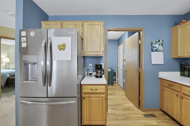 1104 Arbor Oaks Ln, Galloway, OH 43119 - kitchen with stainless steel refrigerator with ice dispenser, light brown cabinetry, light countertops, and light wood-type flooring