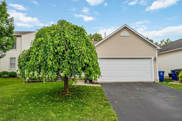 1344 Bluffton Ct, Columbus, OH 43228 - obstructed view of property with asphalt driveway, a front lawn, and an attached garage