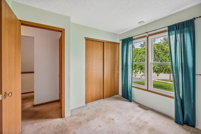 1344 Bluffton Ct, Columbus, OH 43228 - unfurnished bedroom featuring multiple windows, carpet, a closet, and a textured ceiling