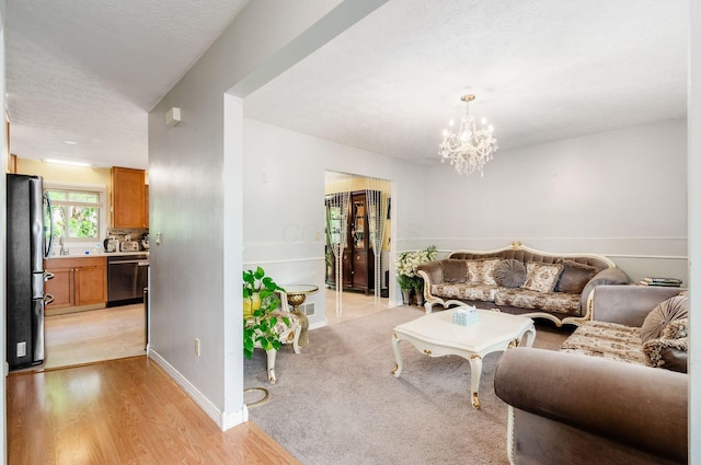 7484 Blue Fox Ln, Columbus, OH 43235 - living room with a chandelier, light wood-type flooring, and a textured ceiling