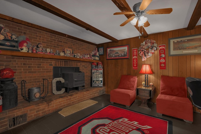2542 Eckert Rd, Lexington, OH 44904 - living room with a wood stove, beamed ceiling, ceiling fan, and wooden walls