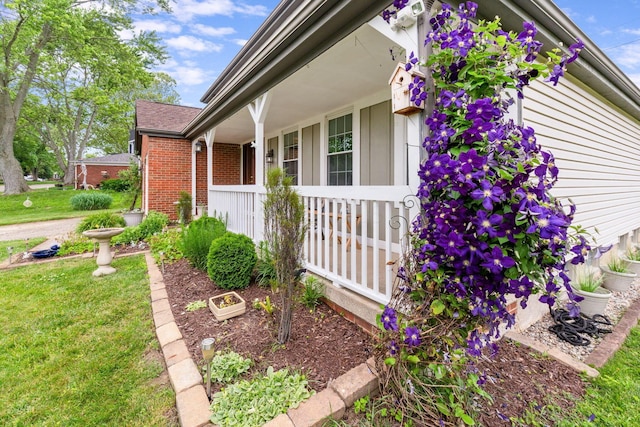 8621 Renford Ct, Powell, OH 43065 - view of property exterior featuring a porch, brick siding, and a lawn