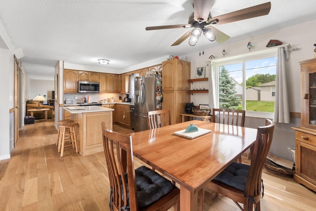 8621 Renford Ct, Powell, OH 43065 - dining space featuring light wood-style floors, a textured ceiling, and ceiling fan