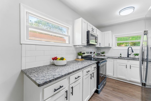 3920 Astor Ave, Columbus, OH 43227 - kitchen featuring range with electric stovetop, stainless steel microwave, light stone counters, and backsplash