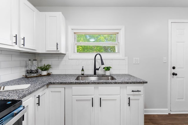3920 Astor Ave, Columbus, OH 43227 - kitchen featuring backsplash, white cabinets, dark stone countertops, and dark wood-style floors