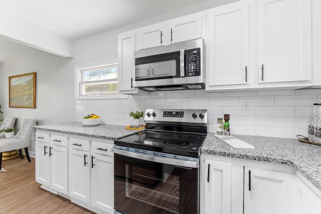 3920 Astor Ave, Columbus, OH 43227 - kitchen with stainless steel appliances, white cabinets, tasteful backsplash, and light stone countertops