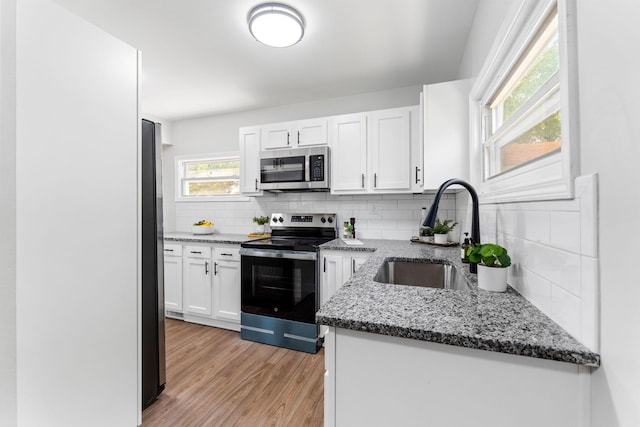 3920 Astor Ave, Columbus, OH 43227 - kitchen with appliances with stainless steel finishes, white cabinets, dark stone countertops, and tasteful backsplash