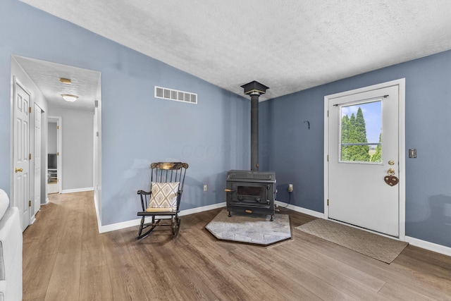 1290 Knorr Rd, Galion, OH 44833 - living area with wood finished floors, a textured ceiling, and a wood stove
