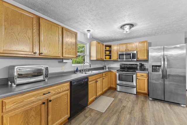 1290 Knorr Rd, Galion, OH 44833 - kitchen with stainless steel appliances, wood finished floors, open shelves, a textured ceiling, and dark countertops