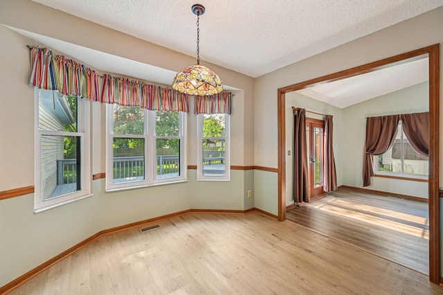 7591 Creekbend Dr, Pickerington, OH 43147 - empty room with plenty of natural light, light wood finished floors, a textured ceiling, and lofted ceiling