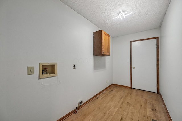 7591 Creekbend Dr, Pickerington, OH 43147 - washroom with electric dryer hookup, cabinet space, hookup for a washing machine, light wood-type flooring, and a textured ceiling