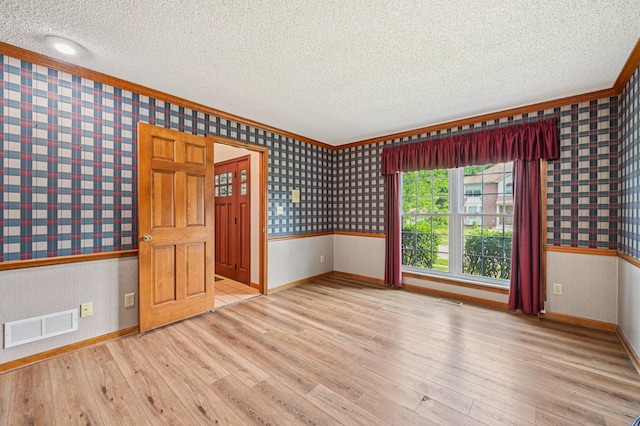 7591 Creekbend Dr, Pickerington, OH 43147 - empty room featuring wallpapered walls, a textured ceiling, wood finished floors, a wainscoted wall, and crown molding