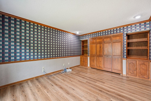 7591 Creekbend Dr, Pickerington, OH 43147 - unfurnished bedroom featuring wallpapered walls, crown molding, light wood-type flooring, a textured ceiling, and a closet