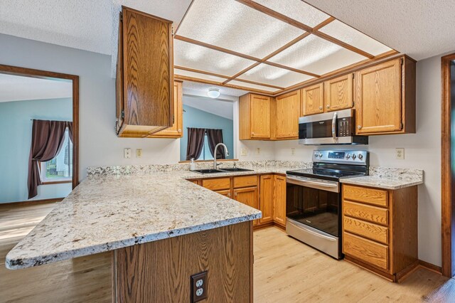 7591 Creekbend Dr, Pickerington, OH 43147 - kitchen with stainless steel appliances, light wood-style flooring, a peninsula, light stone counters, and a textured ceiling