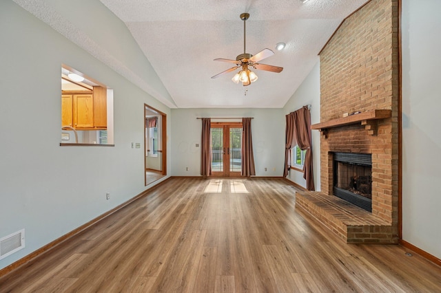 7591 Creekbend Dr, Pickerington, OH 43147 - unfurnished living room with vaulted ceiling, light wood finished floors, ceiling fan, a brick fireplace, and french doors