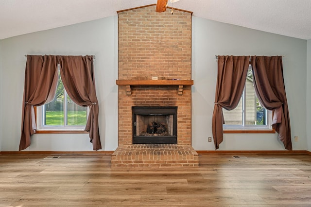 7591 Creekbend Dr, Pickerington, OH 43147 - unfurnished living room featuring lofted ceiling, wood finished floors, a brick fireplace, and healthy amount of natural light