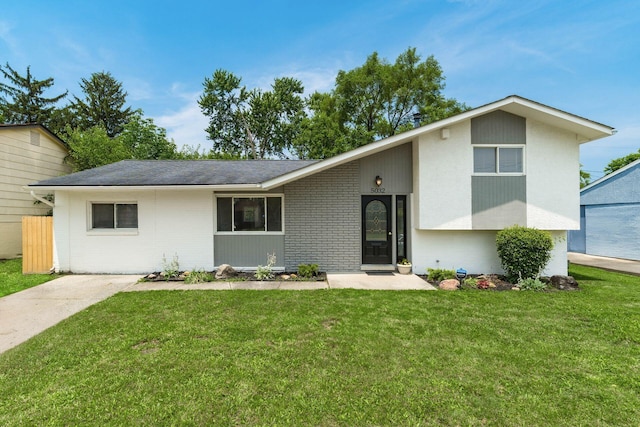 5032 Labelle Dr, Columbus, OH 43232 - view of front of house with brick siding, a front yard, and a shingled roof