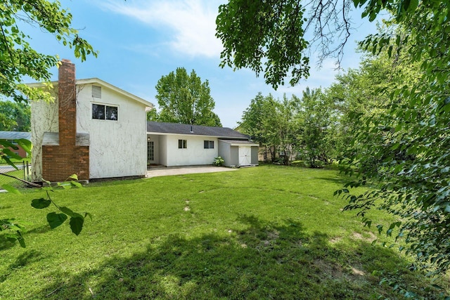 5032 Labelle Dr, Columbus, OH 43232 - back of property with stucco siding, a patio, and a chimney