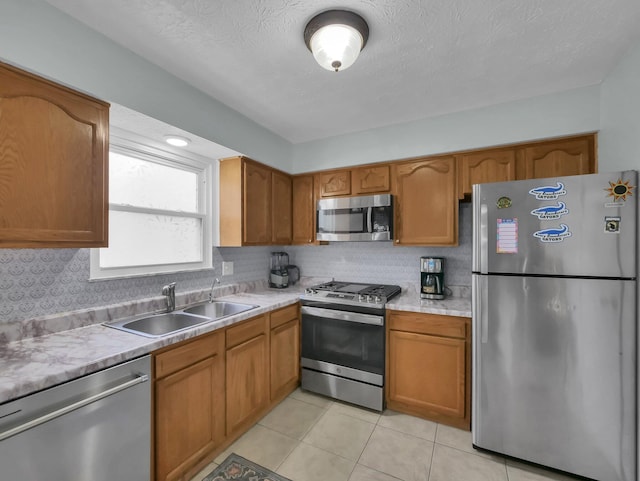 4809 King Albert Dr Unit 1A, Hilliard, OH 43026 - kitchen featuring appliances with stainless steel finishes, tasteful backsplash, light countertops, brown cabinets, and a textured ceiling