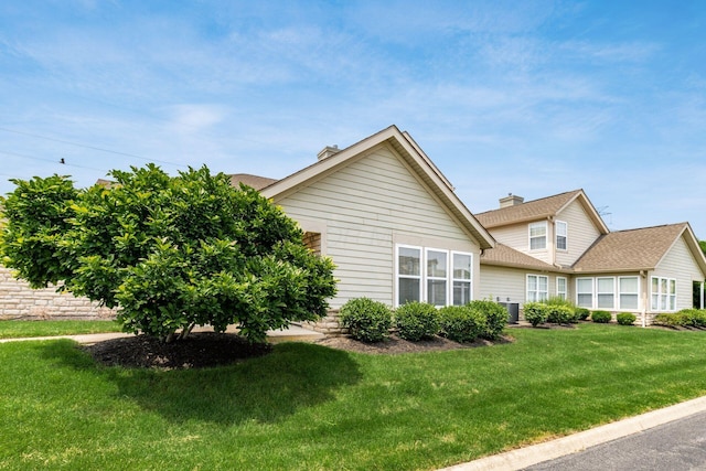8209 Farm Crossing Cir, Powell, OH 43065 - view of side of home featuring a lawn, a chimney, and a shingled roof
