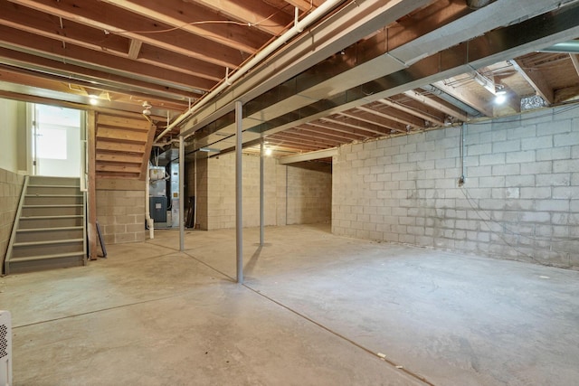 8020 Glenmore Dr, Powell, OH 43065 - below grade area featuring stairs, heating unit, and concrete block wall