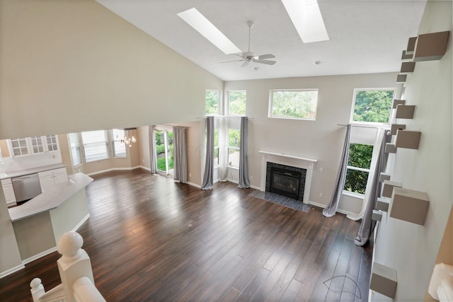 8020 Glenmore Dr, Powell, OH 43065 - unfurnished living room featuring a premium fireplace, high vaulted ceiling, a skylight, dark wood finished floors, and a chandelier