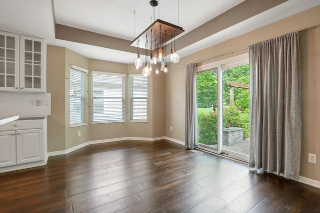 8020 Glenmore Dr, Powell, OH 43065 - unfurnished dining area featuring baseboards and dark wood-type flooring