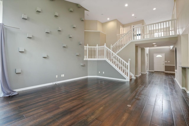 8020 Glenmore Dr, Powell, OH 43065 - unfurnished living room with hardwood / wood-style floors, stairway, a high ceiling, and recessed lighting