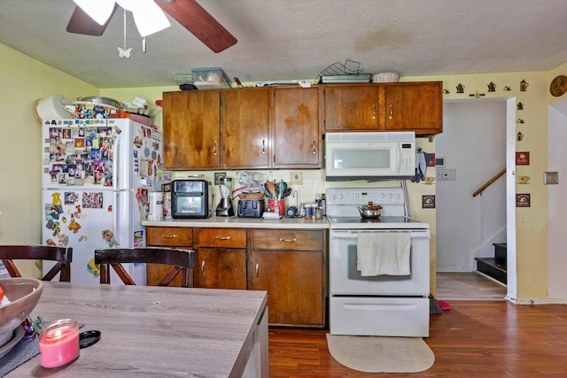 718 Bradwell Dr, Columbus, OH 43207 - kitchen featuring white appliances, ceiling fan, dark wood-style flooring, brown cabinets, and light countertops