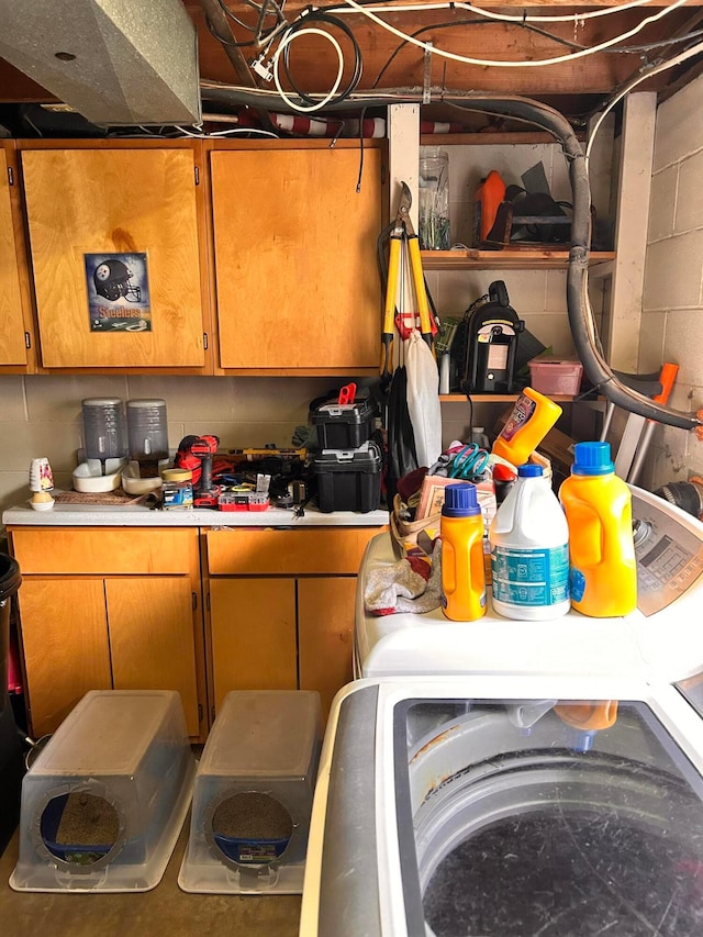 718 Bradwell Dr, Columbus, OH 43207 - kitchen with light countertops, concrete block wall, brown cabinets, and washer / clothes dryer
