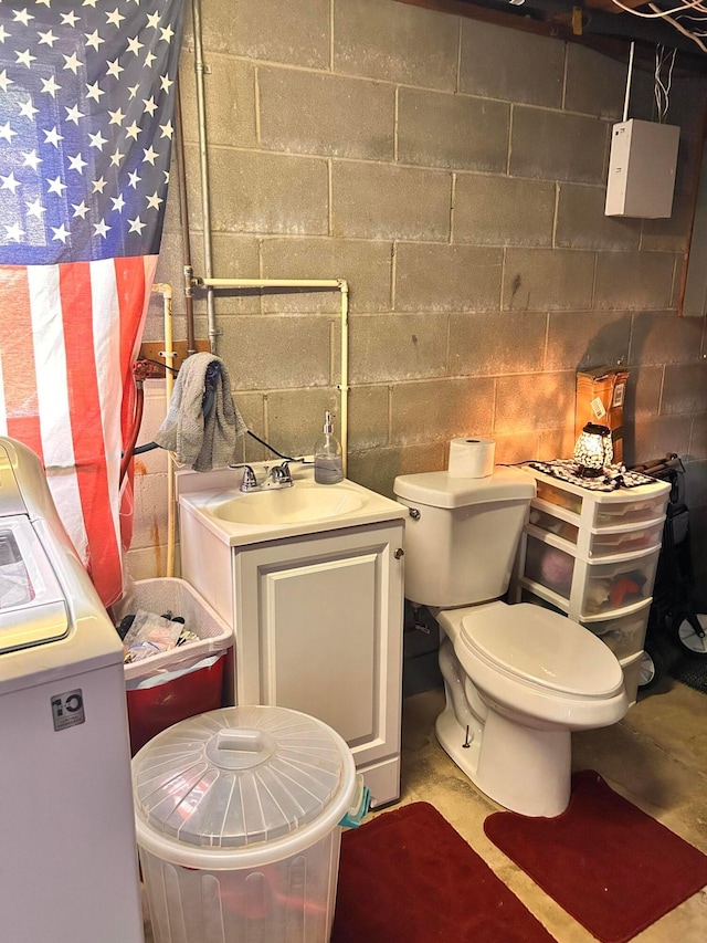 718 Bradwell Dr, Columbus, OH 43207 - bathroom featuring concrete block wall, washer / clothes dryer, vanity, and concrete floors