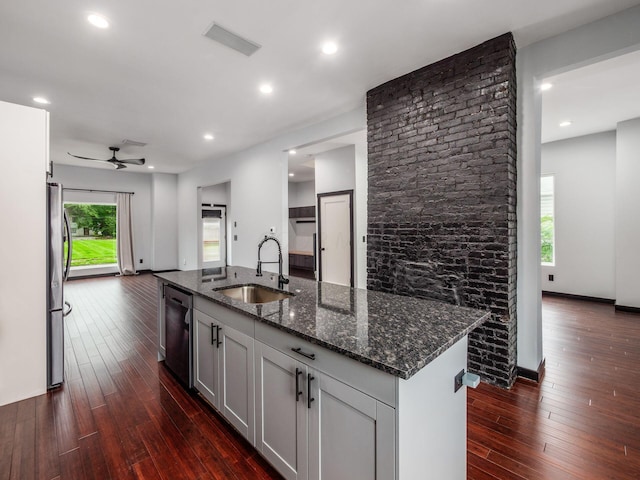 241 N 17th St, Columbus, OH 43203 - kitchen with appliances with stainless steel finishes, ceiling fan, dark stone counters, dark wood finished floors, and an island with sink