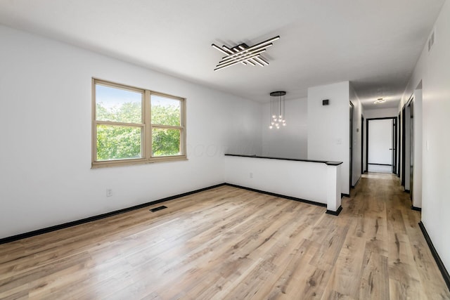 1908 Lost Valley Rd, Powell, OH 43065 - empty room with light wood-type flooring and a chandelier