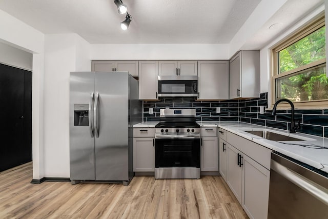 1908 Lost Valley Rd, Powell, OH 43065 - kitchen featuring appliances with stainless steel finishes, gray cabinetry, light wood-type flooring, and light countertops