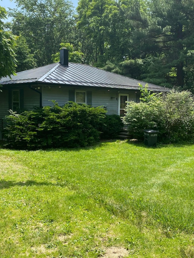 12170 Fairview Rd SE, Heath, OH 43056 - view of property exterior with a standing seam roof, a chimney, a lawn, and a metal roof