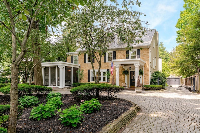 233 Preston Rd, Columbus, OH 43209 - colonial home with a gate, a sunroom, and brick siding
