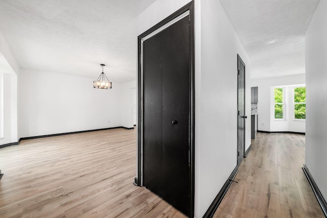 2840 Harnet Ct, Columbus, OH 43231 - hall with light wood-type flooring, a chandelier, and a baseboard heating unit