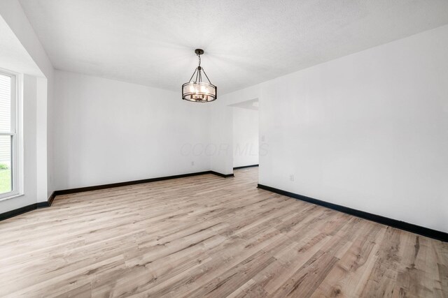 2840 Harnet Ct, Columbus, OH 43231 - empty room with wood finished floors and a chandelier