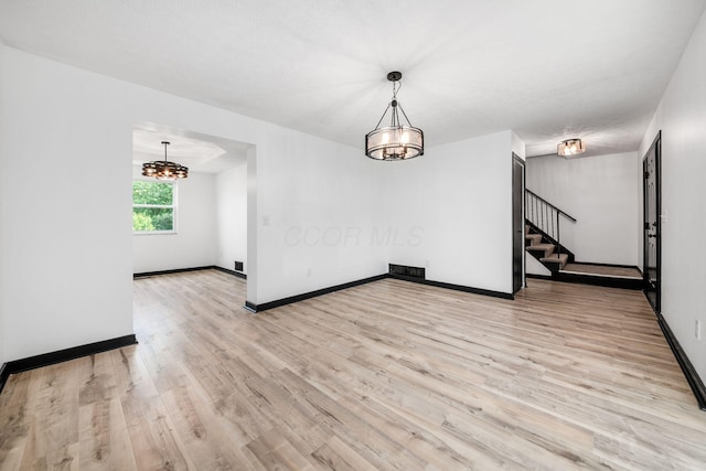 2840 Harnet Ct, Columbus, OH 43231 - unfurnished dining area with stairs, light wood-style flooring, and a chandelier