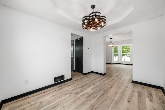 2840 Harnet Ct, Columbus, OH 43231 - empty room featuring a chandelier, light wood-style floors, and a tray ceiling