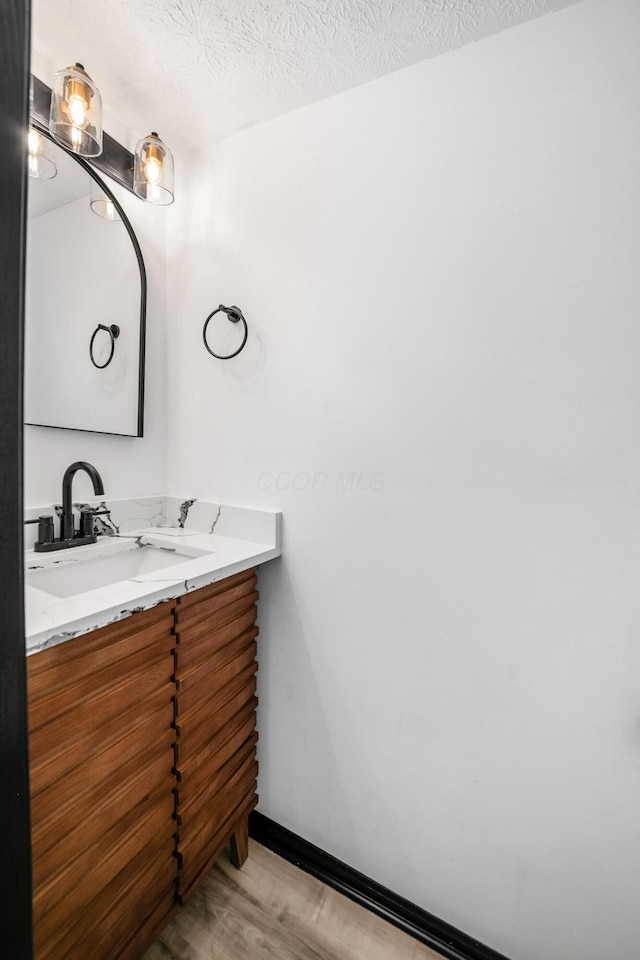 2840 Harnet Ct, Columbus, OH 43231 - bathroom with wood finished floors, vanity, and a textured ceiling