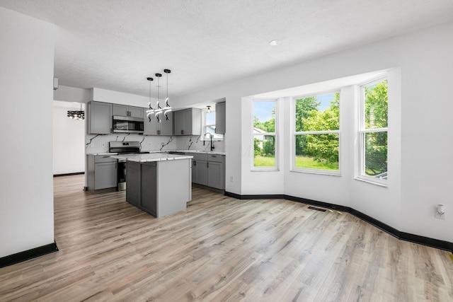 2840 Harnet Ct, Columbus, OH 43231 - kitchen with appliances with stainless steel finishes, gray cabinets, plenty of natural light, light wood-style floors, and a textured ceiling