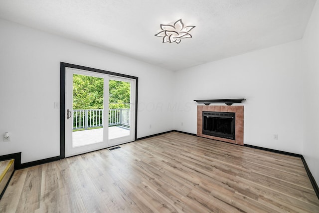 2840 Harnet Ct, Columbus, OH 43231 - unfurnished living room with light wood finished floors and a tile fireplace
