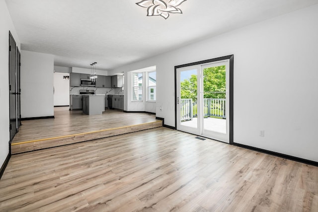 2840 Harnet Ct, Columbus, OH 43231 - unfurnished living room featuring light wood-type flooring and a chandelier