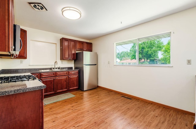 668 Kenilworth Ct, Columbus, OH 43230 - kitchen with appliances with stainless steel finishes, light wood-type flooring, dark countertops, and dark brown cabinets