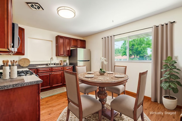 668 Kenilworth Ct, Columbus, OH 43230 - kitchen with reddish brown cabinets, stainless steel appliances, light wood-type flooring, and dark countertops